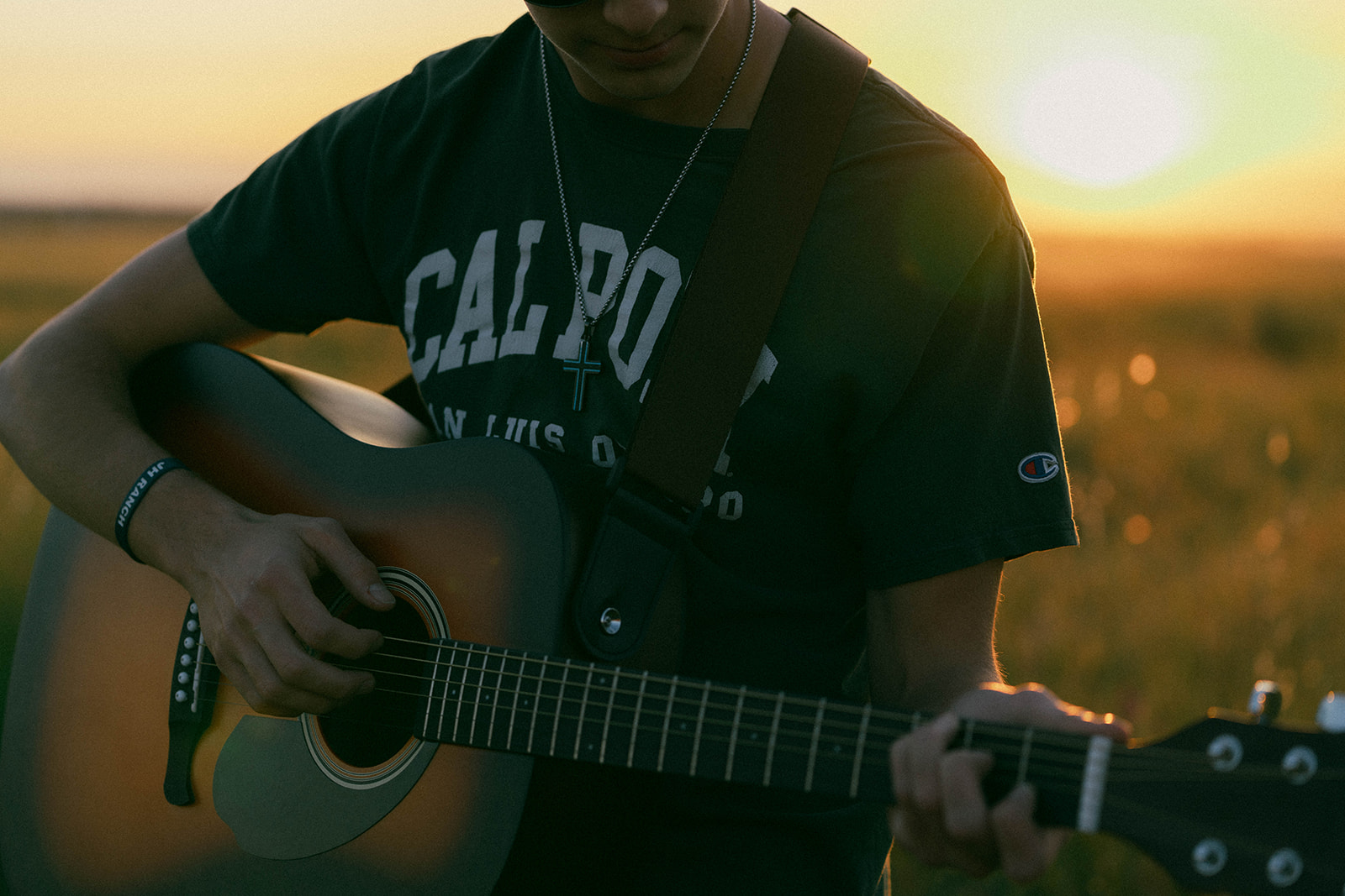 Hunter playing guitar in golden field